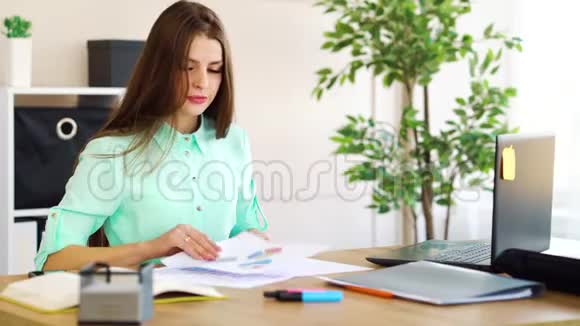 压力大的女商人在桌上的文件中寻找图表视频的预览图