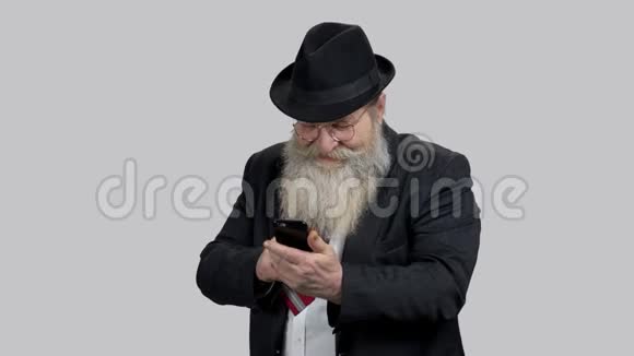 老快乐的人用他的手机在网上显示拇指视频的预览图