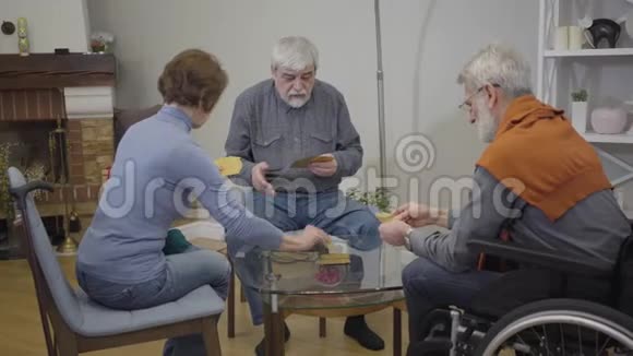 白人老人在养老院和朋友打牌的肖像退休人员在室内享受夜晚重点视频的预览图