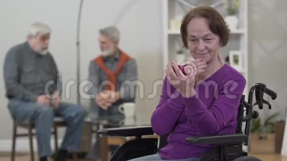 积极的老年白种人女人看着手镜微笑着男人在后台聊天可爱的女性视频的预览图