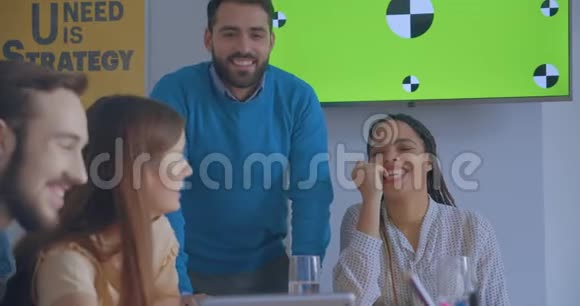 阳光办公室的年轻同事用平板电脑在线电话会议发色背景笑得开心视频的预览图