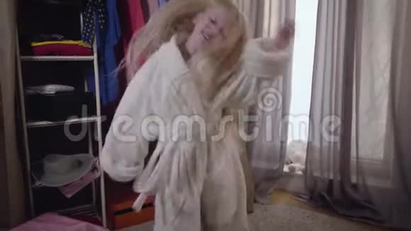开朗微笑的白人女孩穿着白色浴袍在衣柜前跳舞可爱的孩子戴着优雅的帽子视频的预览图