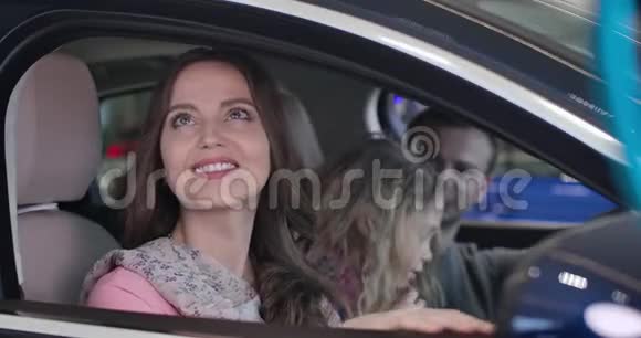 幸福的年轻白种人女人和家人坐在车里微笑的特写肖像美丽的母亲和妻子视频的预览图