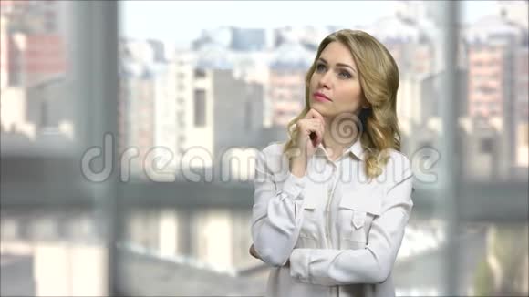 一位年轻的金发商业女性在办公室思考的肖像视频的预览图