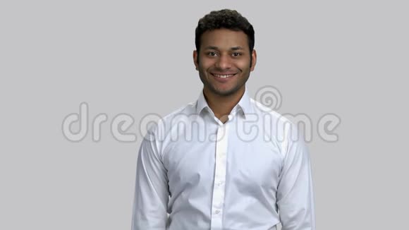 快乐的年轻棕色皮肤男人穿白色正式衬衫的肖像视频的预览图
