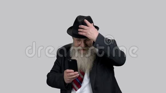很情绪化的爷爷在他的智能手机上拍照视频的预览图