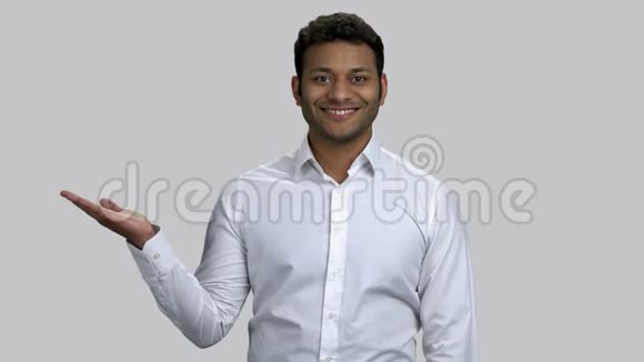 快乐的印度教年轻男子指着他的空掌为共空间视频的预览图