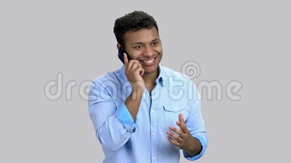 快乐兴奋的深色皮肤男人在电话中交谈的肖像视频的预览图