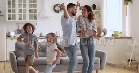 无忧无虑的父母和可爱的孩子们在厨房里尽情跳舞视频的预览图