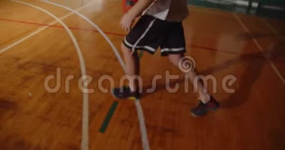 年轻的职业篮球运动员把球投进篮筐夜晚黑暗侧影后视运球视频的预览图
