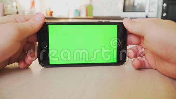 男人手里拿着智能手机手里拿着绿色屏幕手里拿着带有色度键的手机白色背景视频的预览图