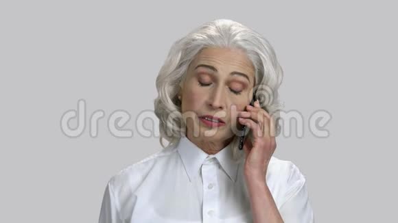 有着白发的老太太在手机上说话的肖像视频的预览图