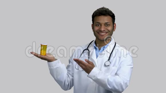 年轻的深色皮肤的医生广告罐的药丸视频的预览图