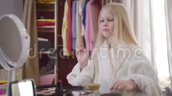 镜头放大集中白人女孩选择化妆品和化妆可爱的金发孩子在休息视频的预览图