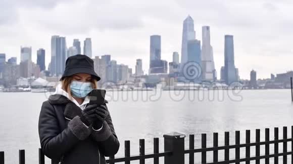 冠状病毒大流行在纽约背景下女人戴着智能手机防护面罩视频的预览图