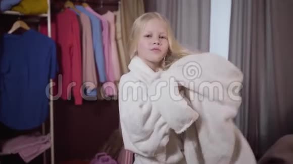 镜头接近迷人的白种人女孩用毛巾擦干头发微笑的孩子在她房间里休息的画像视频的预览图