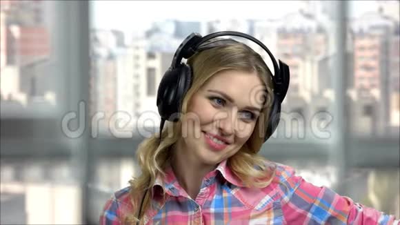 年轻快乐女人戴着耳机说话的肖像视频的预览图