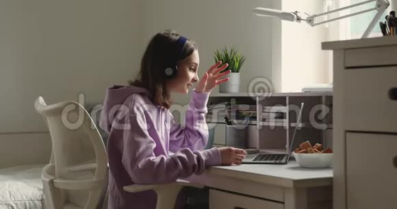 戴耳机的少女在家里召开笔记本电脑会议视频的预览图