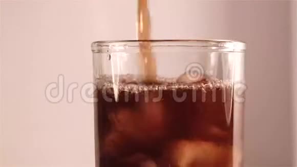 冰镇可乐倒入装有冰块的玻璃杯中视频的预览图