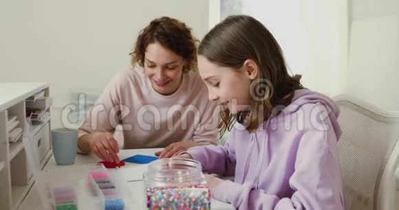 十几岁的女儿和妈妈在家里玩马赛克游戏视频的预览图