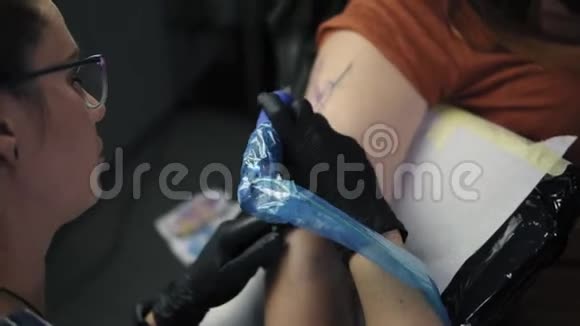 那个女孩纹身大师抽象图案纹身在工作的纹身师一个红头发的女孩纹身视频的预览图