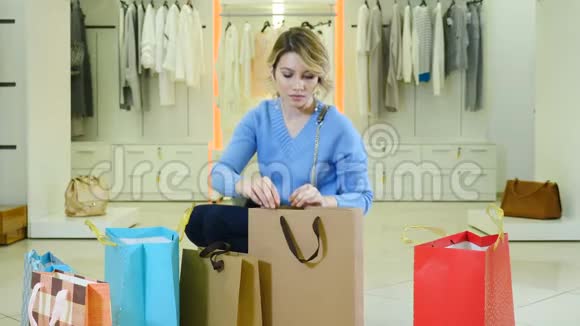 购物概念相当惊讶的购物者女孩r在时尚精品店微笑的相机与纸袋周围黑色视频的预览图