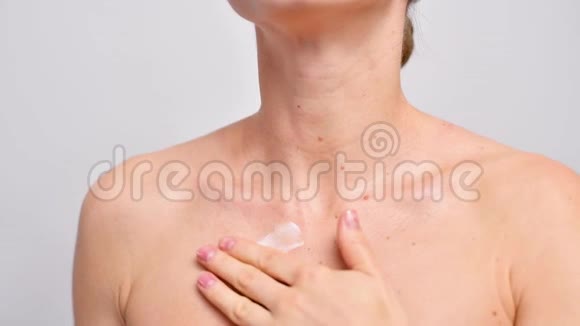 美丽的女人淋浴后在干燥的皮肤上涂抹身体乳液视频的预览图