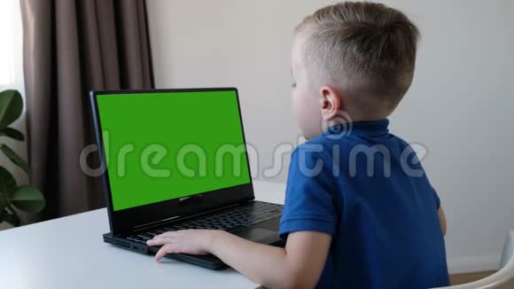 远程学习在线教育可爱的白种人男孩在电脑上做作业同时检疫附睾电晕视频的预览图