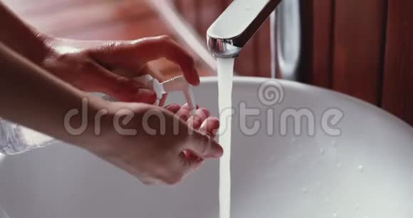 年轻女子用液体肥皂洗手液凝胶特写视频的预览图