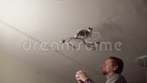 人在房间的天花板上安装吊灯视频的预览图