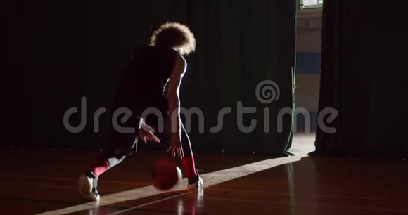 头发卷曲的白种人篮球运动员准备进入地板剪影黑暗的后台光束视频的预览图