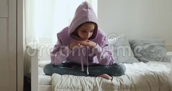 一个不高兴的少女独自坐在床上想问题视频的预览图