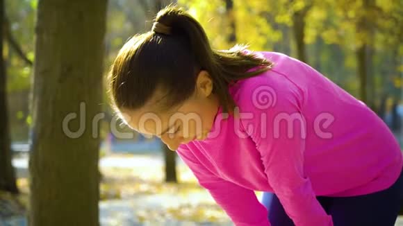 运动健美女在秋季公园慢跑后放松和呼吸困难视频的预览图