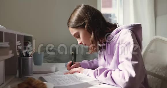 十几岁的女孩在家里读书读课本做笔记视频的预览图