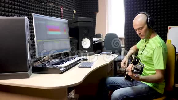 吉他演奏者在录音室记录乐器的声音视频的预览图