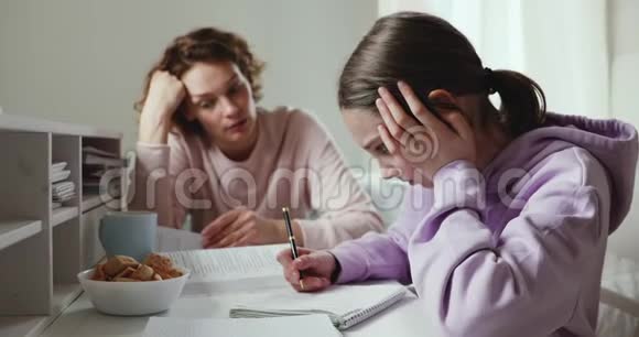 愤怒的妈妈责骂懒惰的女儿在家做作业视频的预览图