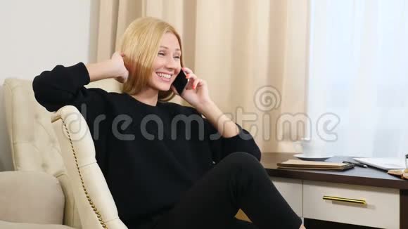 幸福成功的女人在明亮的公寓里使用手机舒适地坐着商务及假日旅游视频的预览图