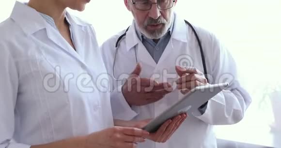 医疗队两名医生使用片剂握手特写视频的预览图