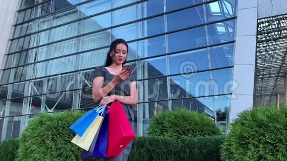 购物女人在黑色星期五假日的商场附近拿着彩包视频的预览图