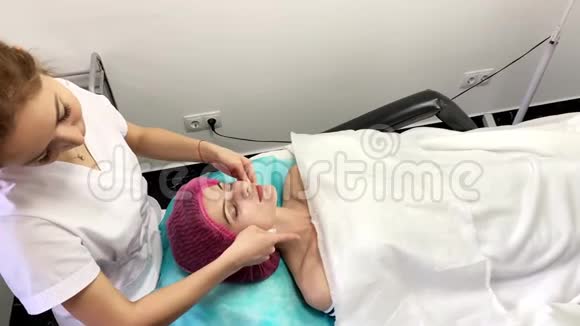 水疗中心美丽的年轻女子正在水疗中心戴面膜眼睛上挂着黄瓜视频的预览图