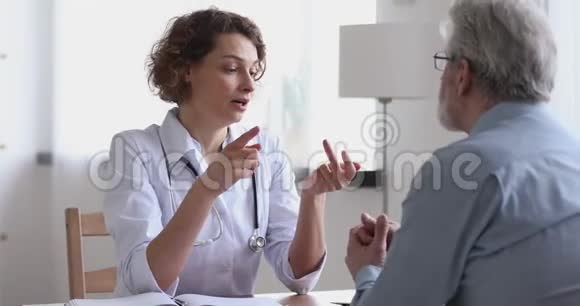 微笑的女医生提供保健建议握手的老年病人视频的预览图