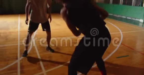 两名年轻的篮球运动员打篮球比赛业余爱好者大厅体育球拍运球进攻夜间比赛视频的预览图