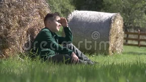 一个小男孩看着坐在草地上的阳光视频的预览图