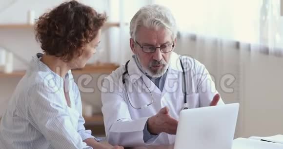 老医生咨询女性病人显示笔记本电脑的测试结果视频的预览图