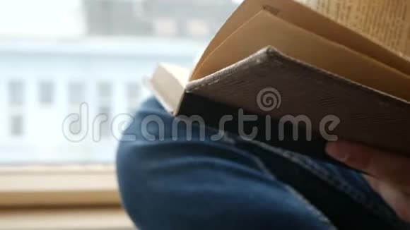 青年学生阅读窗台上的布朗书视频的预览图