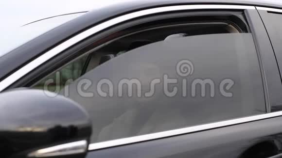 美丽的女人坐在车里放下侧窗视频的预览图