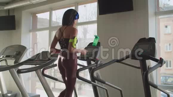 可爱的健身女性在健身房跑步机上跑步视频的预览图