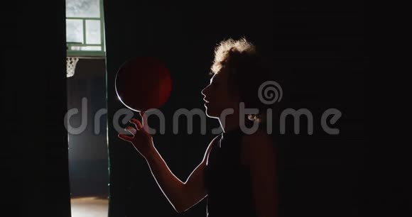 年轻的白种人卷发篮球运动员准备好了他的手指上旋转着明亮的光影技巧视频的预览图