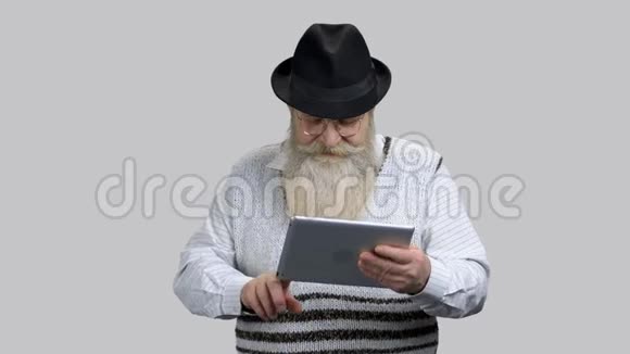 老退休爷爷开始使用他的平板电脑在线交谈视频的预览图