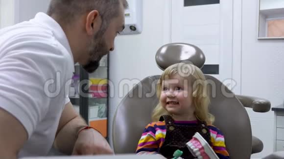 牙医会和一个可爱的小女孩谈论用刷牙清洁牙齿视频的预览图